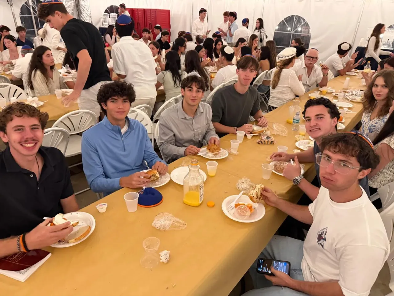 A long table of students at a holiday dinner at Chabad UF
