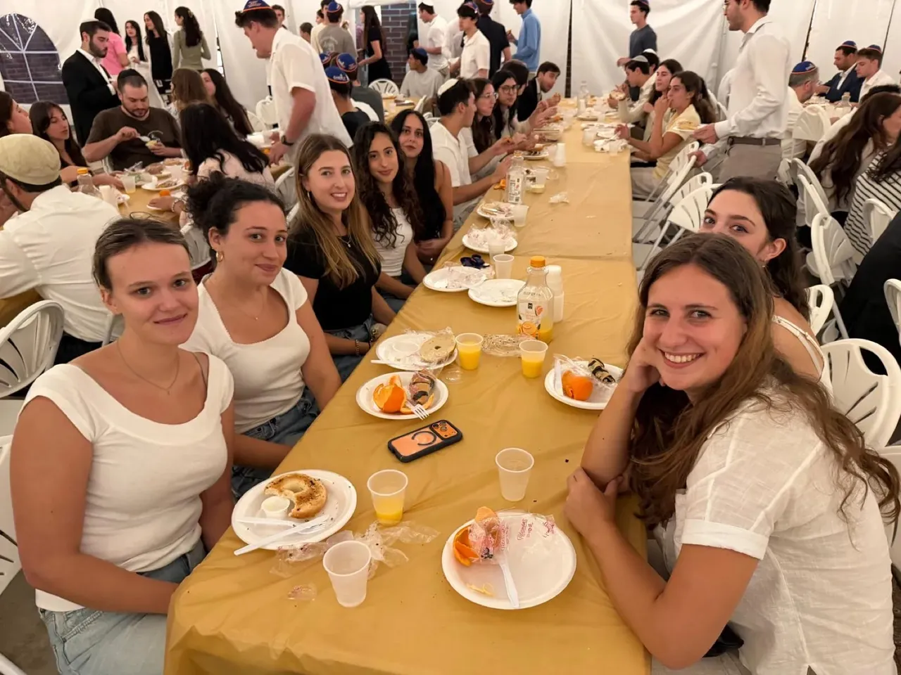Students around a long dinner table at Chabad UF