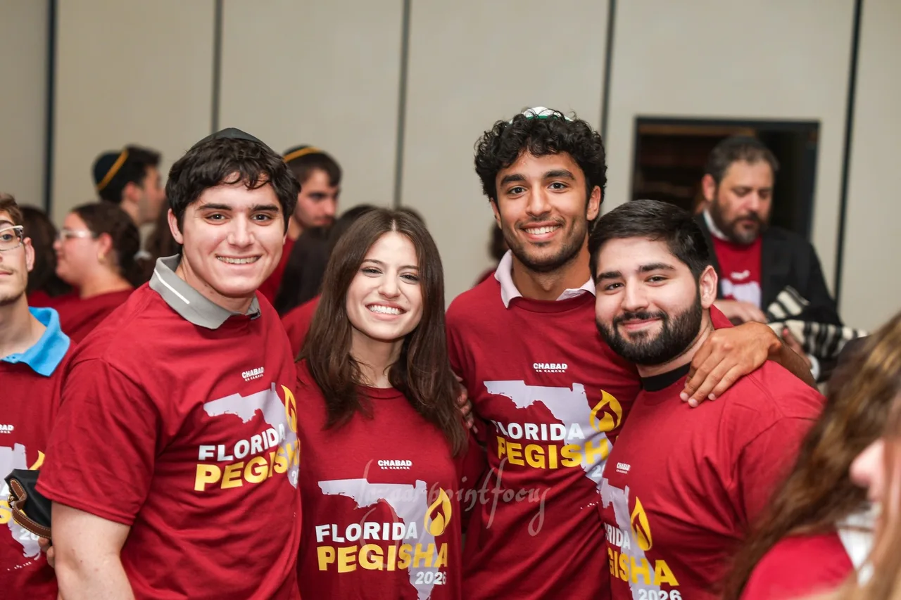Four students in Florida Pegisha shirts smiling together