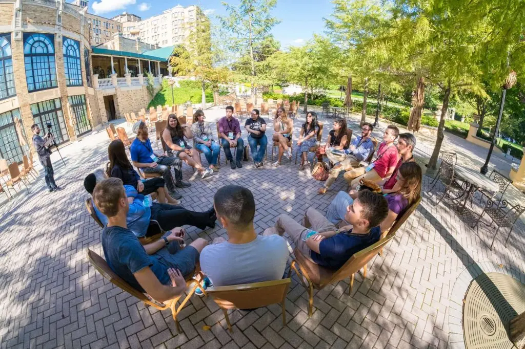 Students seated in an outdoor circle listening to a Chabad on Campus educator