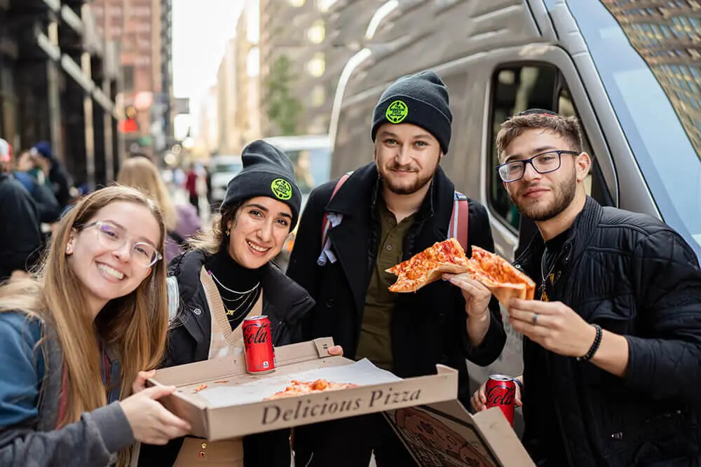 College students sharing kosher pizza at a Chabad on Campus event