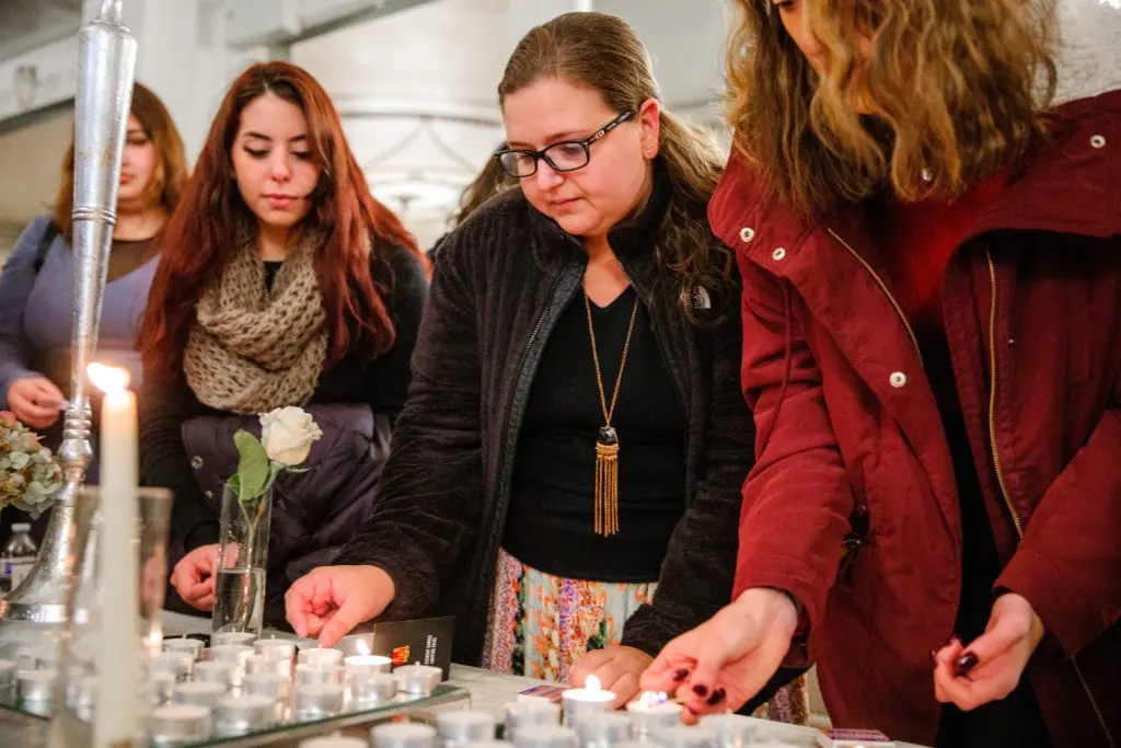 Students lighting Shabbat candles together at a Chabad House