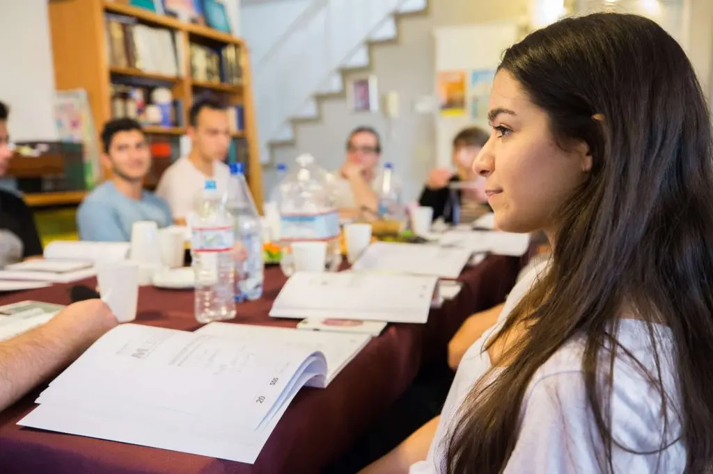 College students taking notes around a table during a Chabad on Campus course