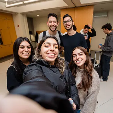 Jewish college students taking a group selfie at a Chabad on Campus event